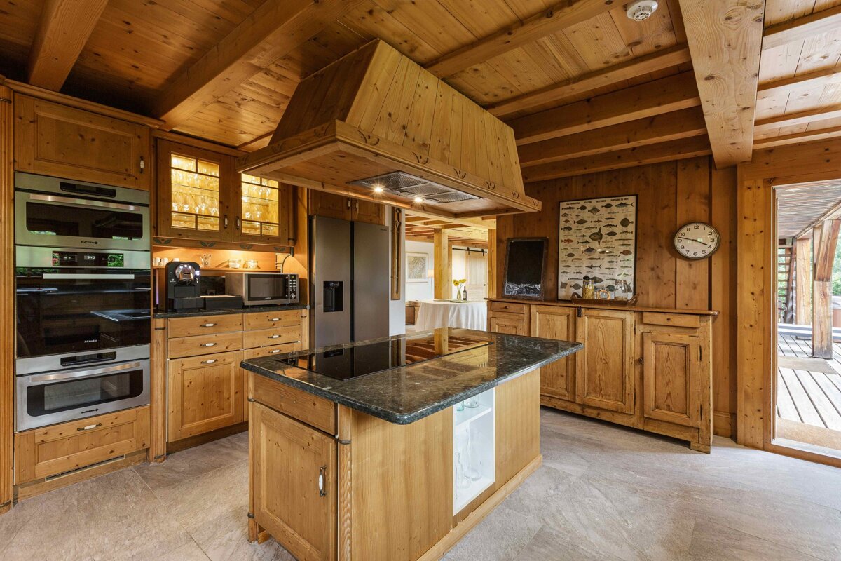 A kitchen with wooden cabinets and a clock on the wall