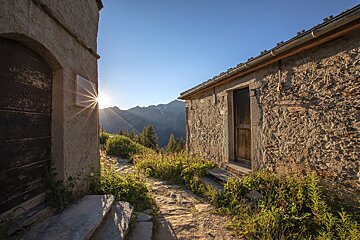 The sun is shining through the doorway of an old building