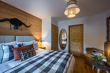 A bedroom with a king size bed and a chair