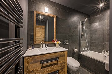 A bathroom with a toilet a sink and a mirror