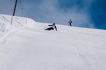 Two people skiing down a snow covered slope