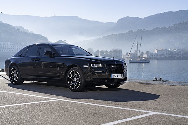 A black rolls royce is parked on the side of the road