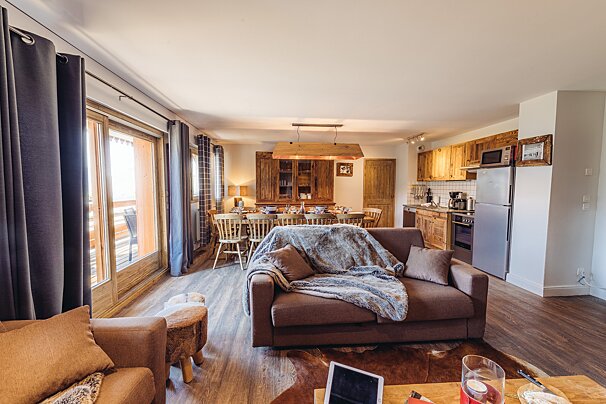A living room with a couch that has a blanket on it