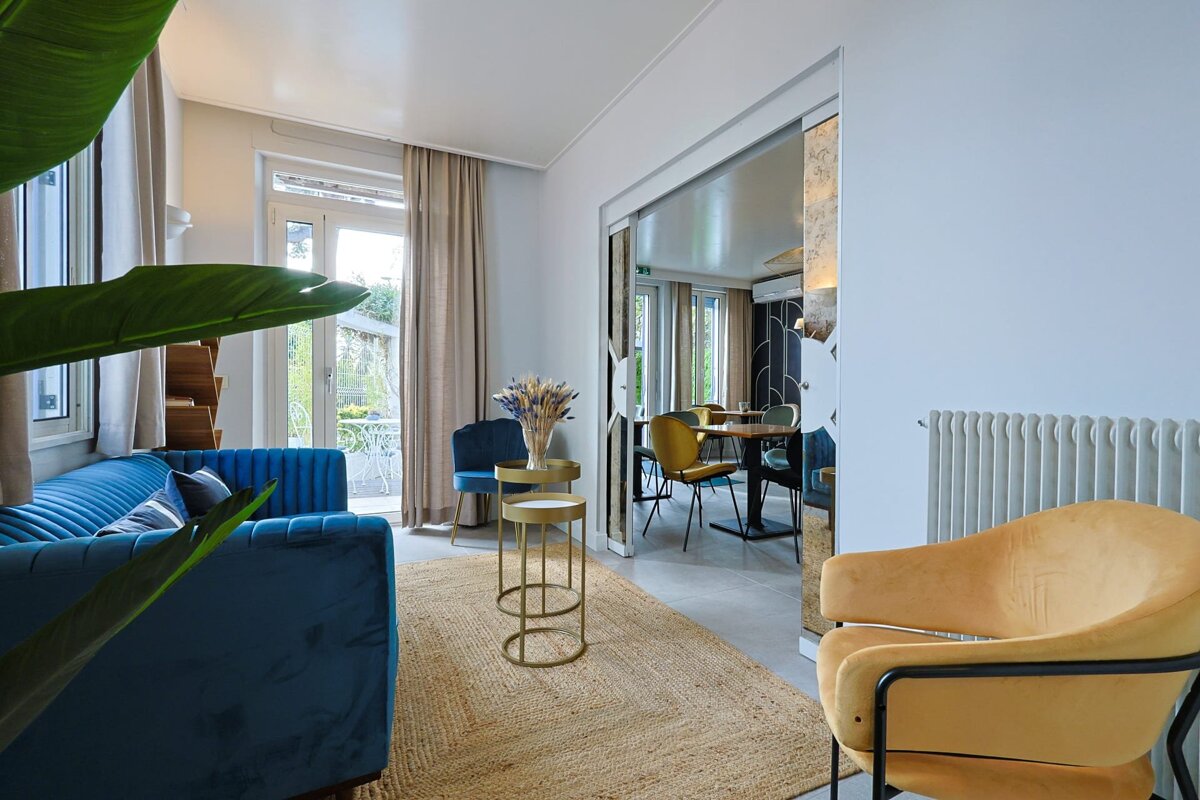 A living room with a blue couch and yellow chairs