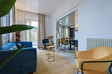 A living room with a blue couch and yellow chairs