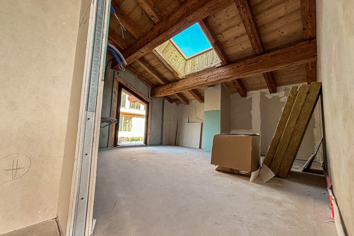 An empty room with a skylight and a box on the floor