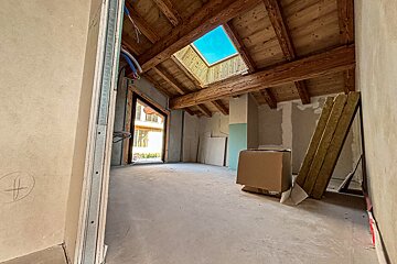 An empty room with a skylight and a box on the floor