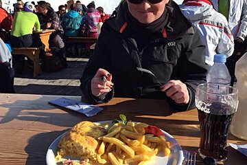 a woman eating a plate of omelette and chips