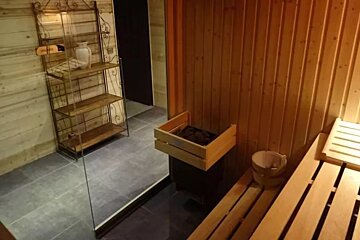 A wooden box in a sauna with a sign that says ' finland ' on it