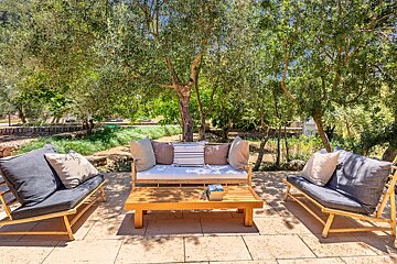 A patio with a couch and chairs and a coffee table
