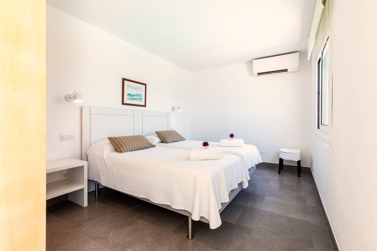 A bedroom with two beds and a picture on the wall