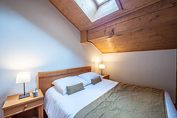 A bedroom with a bed a nightstand and two lamps