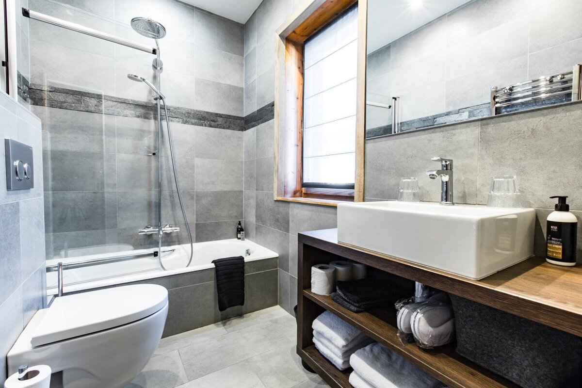 A bathroom with a toilet a sink and a window