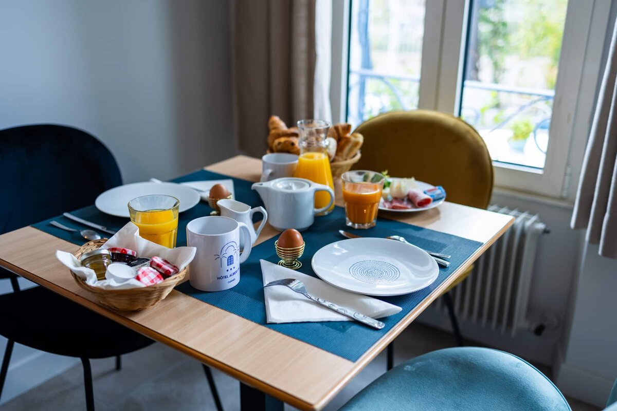 A table set for breakfast with a mug that says hotel de ville