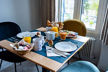 A table set for breakfast with a mug that says hotel de ville