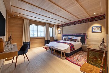 A bedroom with a bed and a desk with a picture on the wall that says ' switzerland '