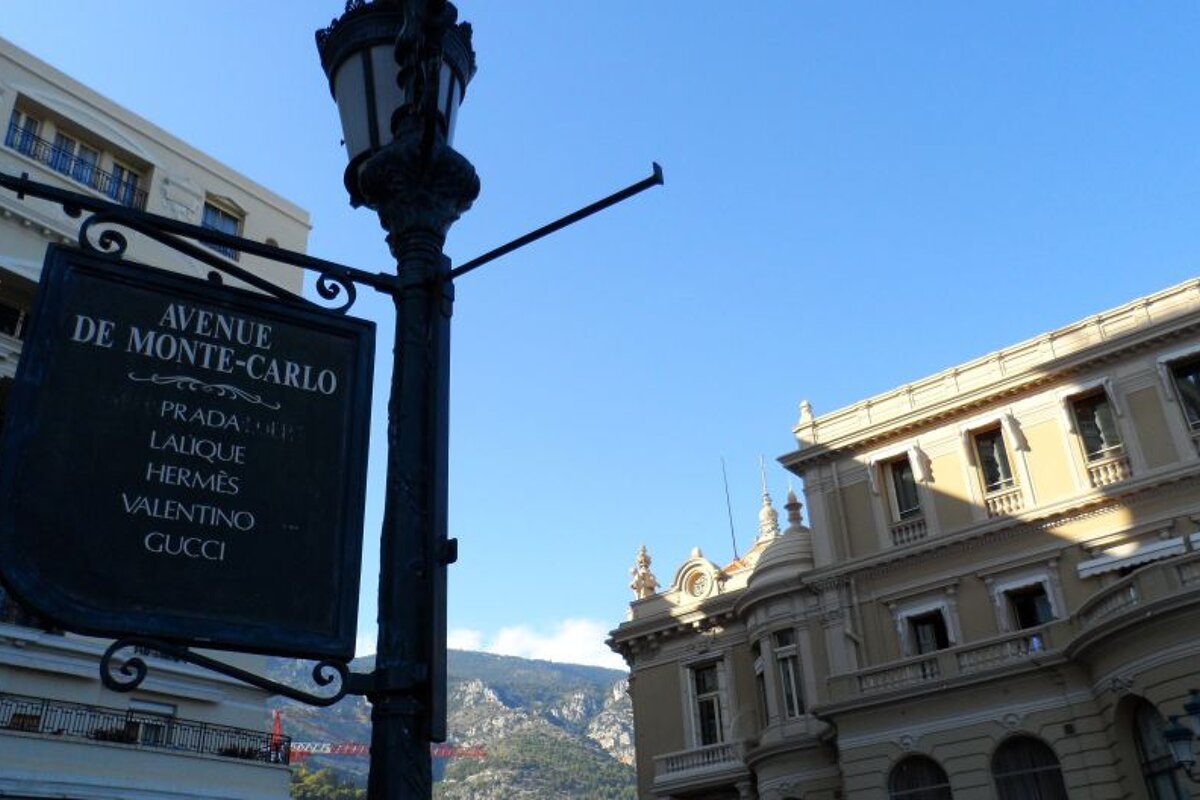 a street sign showing where to go for luxury shops in monte carlo