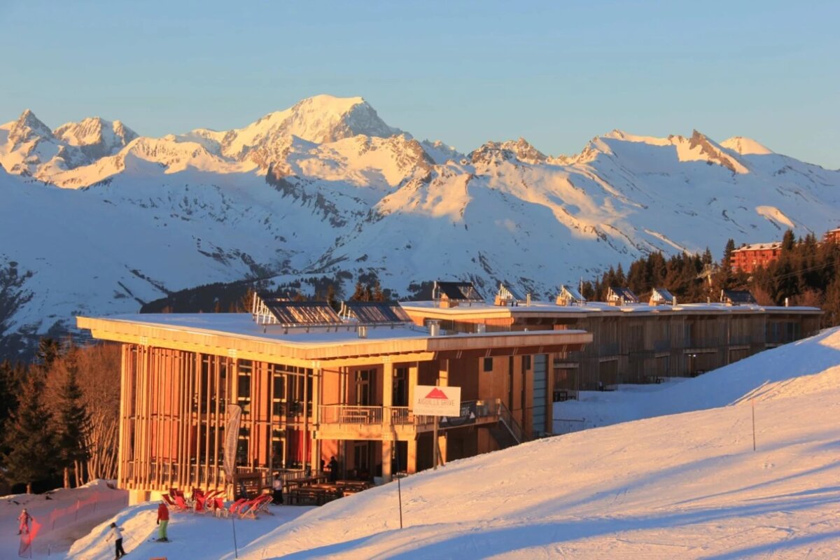 A snowy mountain with a building in the foreground