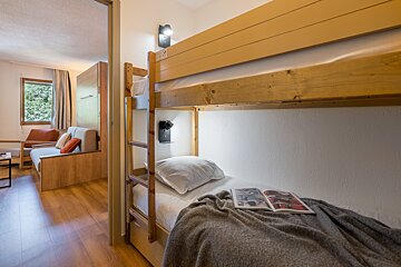 A bedroom with a bunk bed and a book on the bed