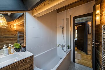 A bathroom with a bathtub a sink and a mirror