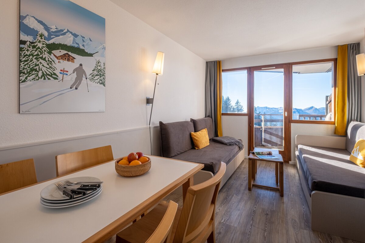 A living room with a painting of skiers on the wall