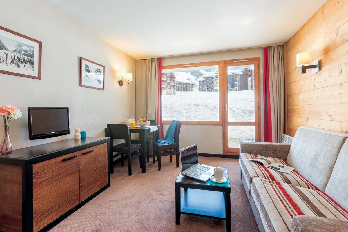 A living room with a couch and a laptop on a table
