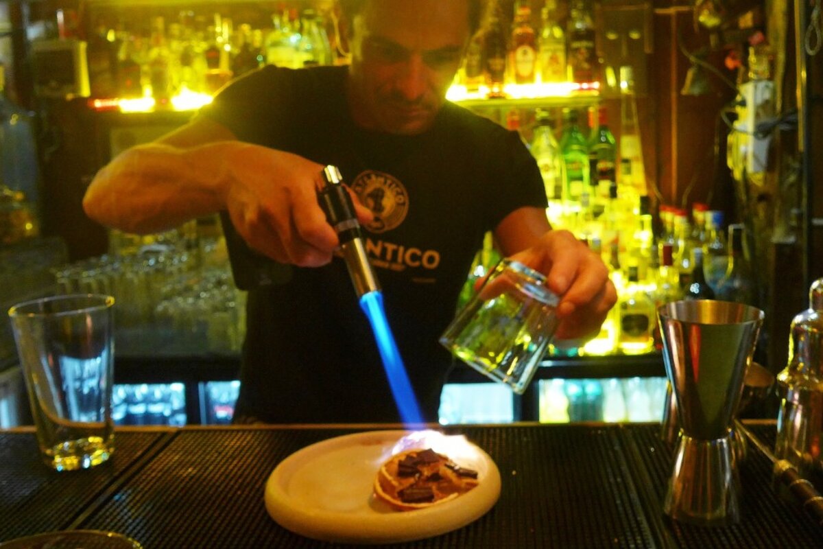 a barman with a gas burner making a cocktail