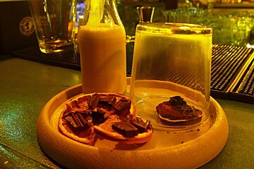 a cocktail and accompaniments on a round platter