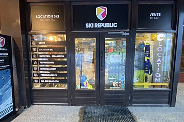 The storefront of SKI REPUBLIC, a ski shop, with large windows displaying winter sports equipment. Signs advertise ski rental, retail, and repair services.