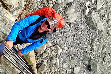 a man climbing down a ladder with a red back pack