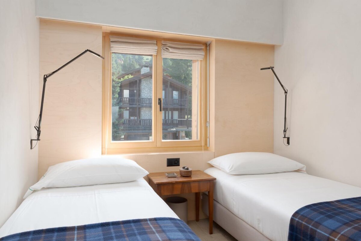 A bedroom with two twin beds and a window