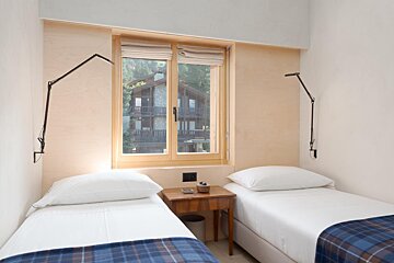 A bedroom with two twin beds and a window