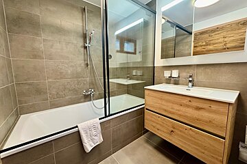 A bathroom with a bathtub a sink and a mirror