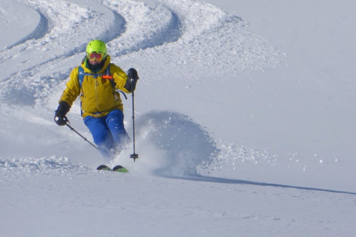 a skier in a yellow jacket