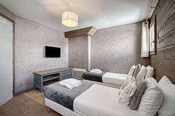 A bedroom with two beds and a flat screen tv