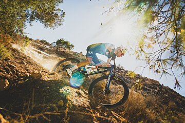 A man riding a mountain bike with a maxxis tire