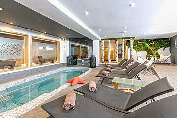 A swimming pool with a few chairs around it