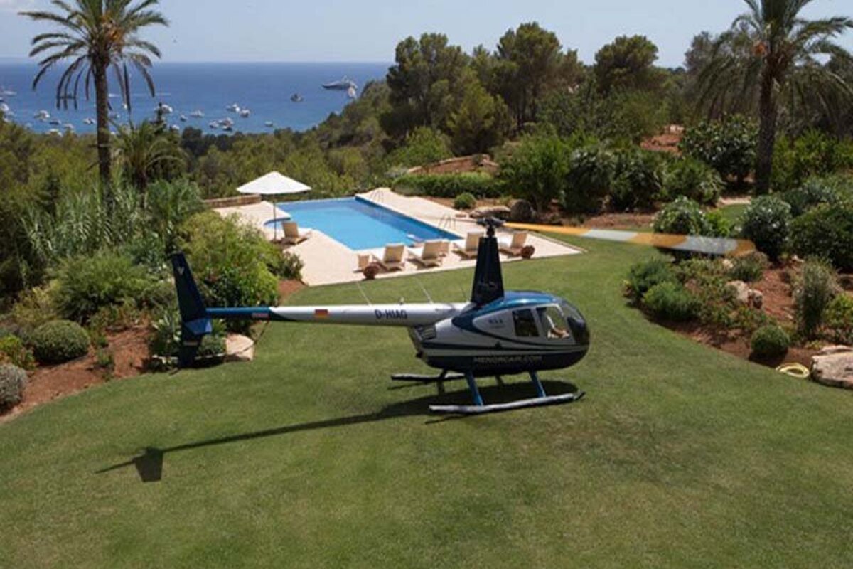 A blue and white helicopter is parked on a lush green lawn