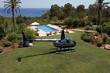 A blue and white helicopter is parked on a lush green lawn