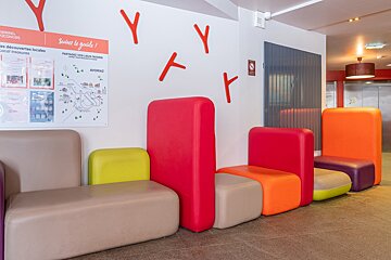 A row of colorful chairs in front of a sign that says