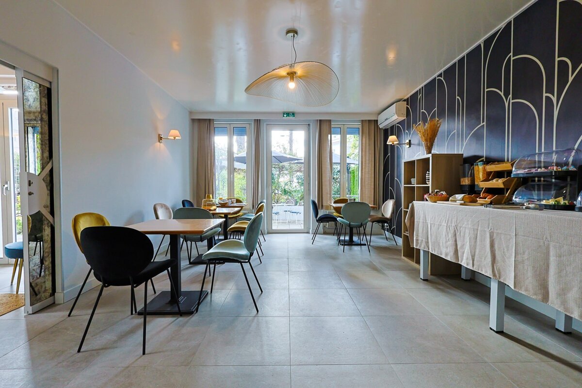 A dining room with tables and chairs and a buffet table