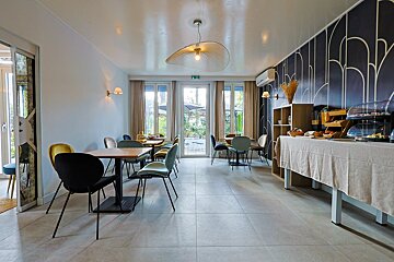A dining room with tables and chairs and a buffet table