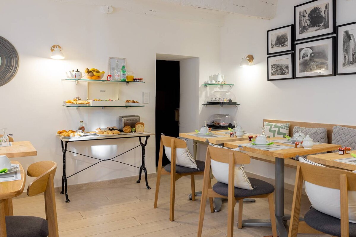 A dining room with tables and chairs and pictures on the wall