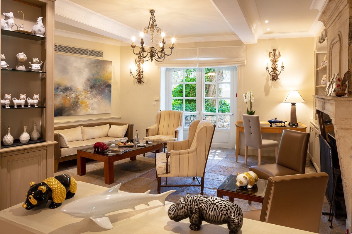 A living room with a painting on the wall above the couch