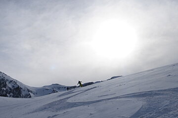 a skier with the sun behind some clouds
