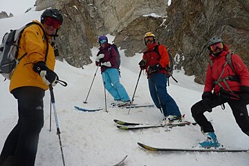skiers taking a break by a rock face