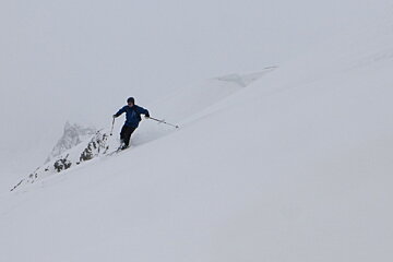 a skier in almost whiteout conditions