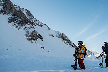 two snowboarders looking at a line