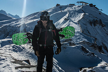 a snowboarder with his board on his back