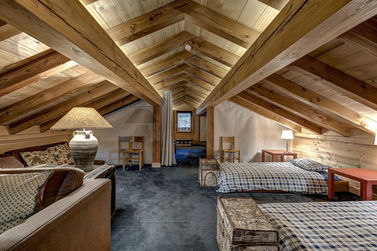 A bedroom with two beds a couch and a lamp